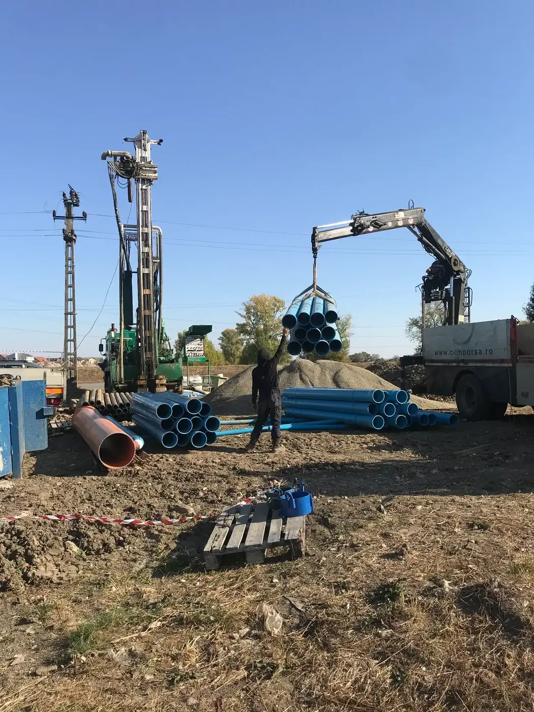 Muncitor Comporsa ghidând un pachet de coloană PVC ridicat cu macaraua de pe camion